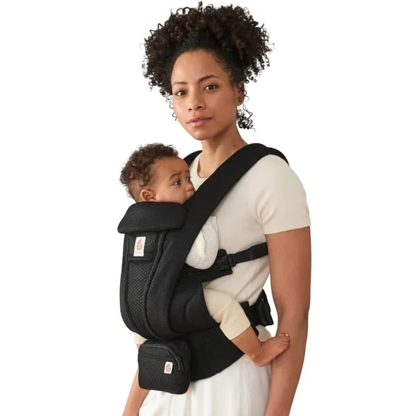 Parent wearing a baby in a black Ergobaby Omni Deluxe mesh carrier