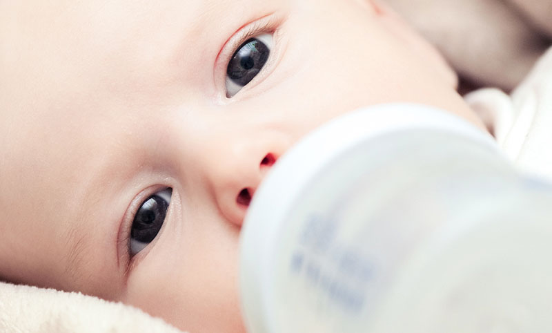 baby biting bottle teat